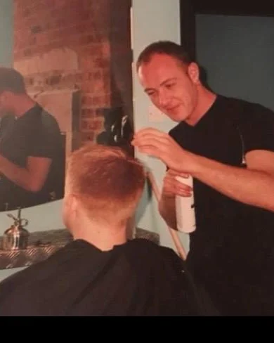 Archive photograph of a younger Jason Scott working behind the chair