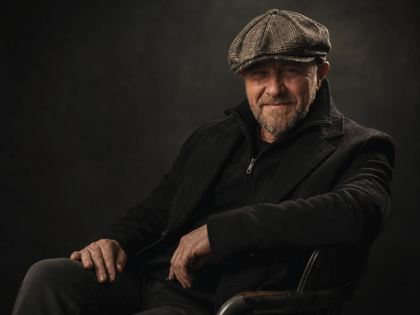 Jason Scott seated in a dark studio portrait